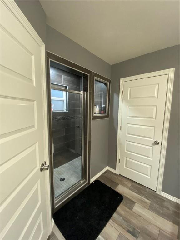 bathroom featuring hardwood / wood-style flooring and walk in shower