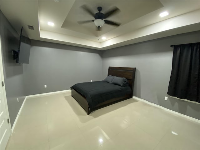 bedroom featuring tile patterned floors, ceiling fan, and a raised ceiling