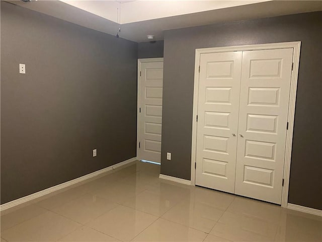 unfurnished bedroom featuring light tile patterned floors and a closet