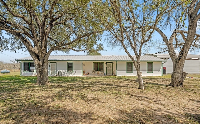 single story home featuring metal roof and a front lawn