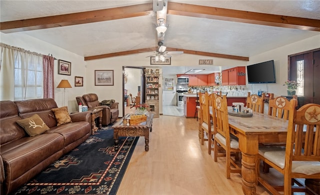 living room featuring light wood-style floors, ceiling fan, and vaulted ceiling with beams