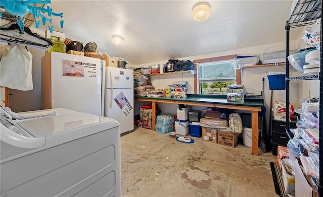 interior space featuring washer / clothes dryer, concrete flooring, and freestanding refrigerator