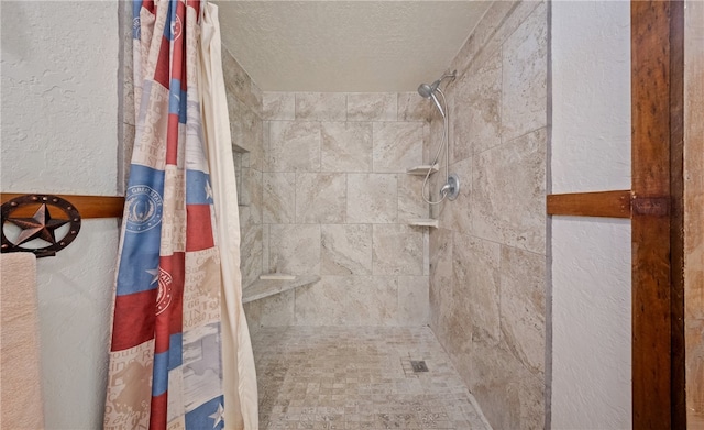 full bathroom featuring tiled shower, a textured ceiling, and a textured wall