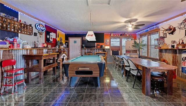 rec room with a textured ceiling, a dry bar, pool table, ceiling fan, and tile patterned flooring