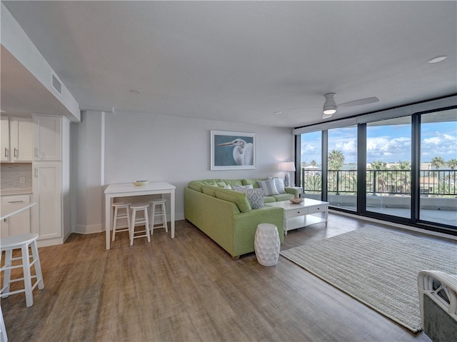 living room with expansive windows, ceiling fan, and light hardwood / wood-style flooring