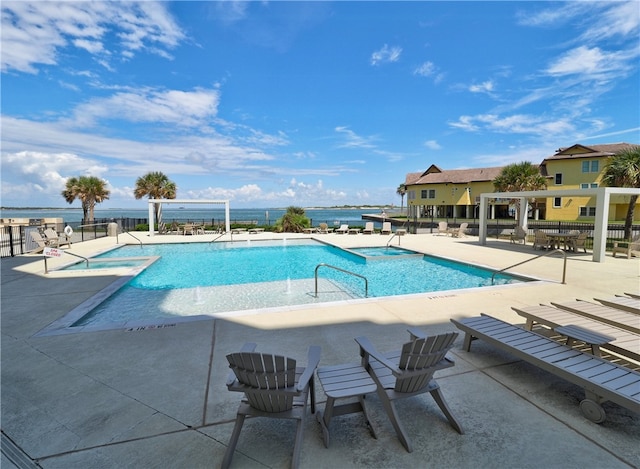 view of swimming pool with a patio and a water view