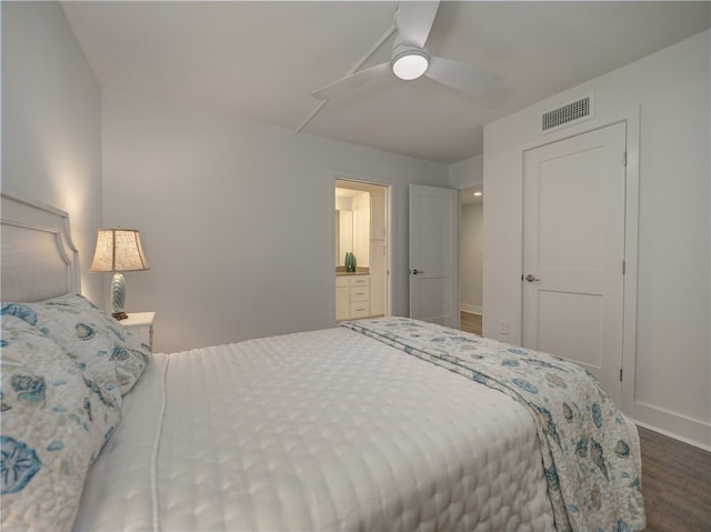 bedroom featuring ceiling fan, dark hardwood / wood-style floors, and connected bathroom