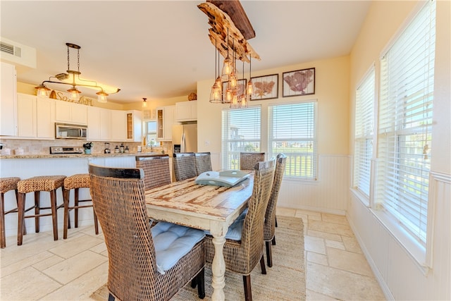 dining room with plenty of natural light, sink, and a notable chandelier