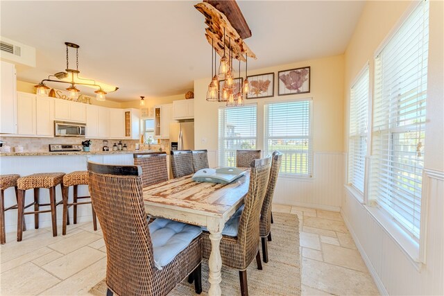 dining room with plenty of natural light, sink, and a notable chandelier