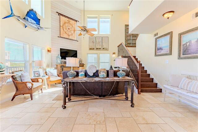 living room with ceiling fan and a high ceiling