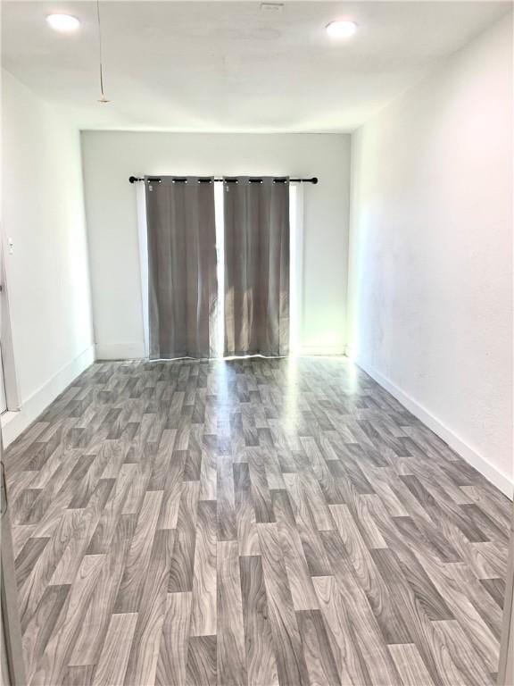 empty room featuring baseboards and wood finished floors