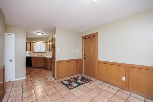 kitchen featuring light tile patterned flooring, dishwasher, and sink