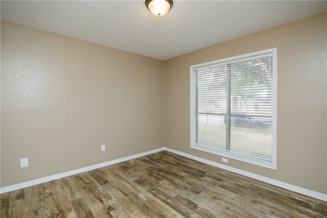 unfurnished room with hardwood / wood-style flooring