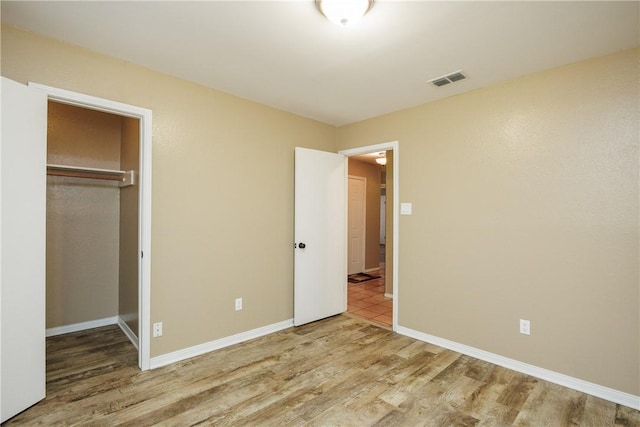 unfurnished bedroom with wood-type flooring and a closet