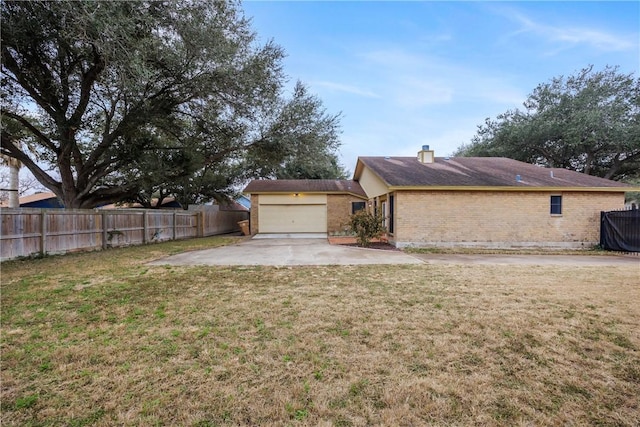 exterior space with a garage and a lawn