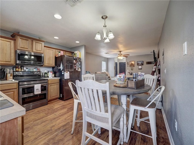 dining space featuring recessed lighting, ceiling fan with notable chandelier, visible vents, and light wood-type flooring