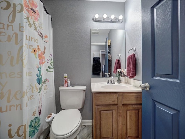 bathroom with curtained shower, wood finished floors, visible vents, toilet, and vanity