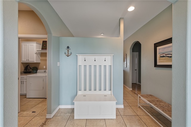 corridor with light tile patterned floors and washer and dryer