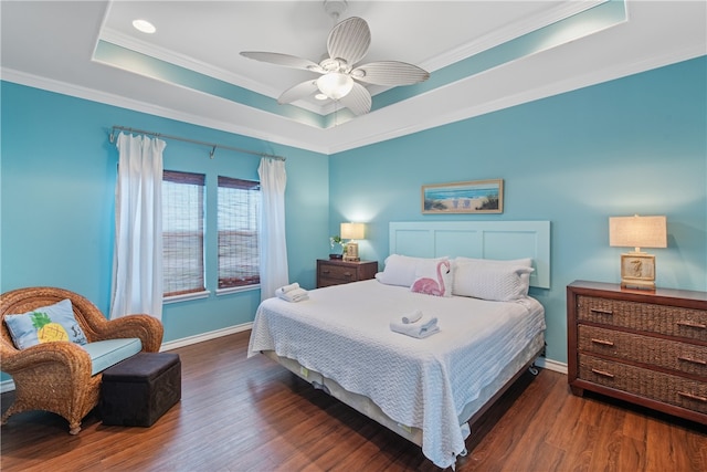 bedroom featuring crown molding, dark hardwood / wood-style flooring, ceiling fan, and a raised ceiling