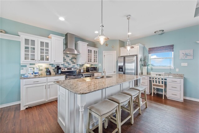 kitchen with dark wood-type flooring, white cabinetry, wall chimney range hood, and stainless steel appliances