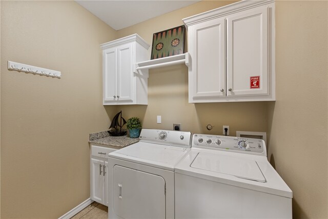 laundry room featuring light tile patterned flooring, cabinets, and separate washer and dryer