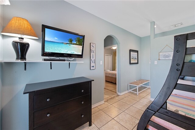 bedroom featuring ensuite bath and light tile patterned floors