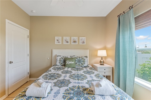 tiled bedroom featuring ceiling fan