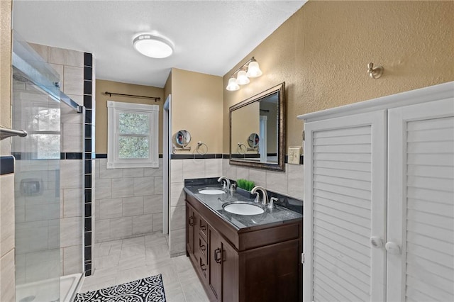 313 N Eleventh St, Fulton, TX 78358 - bathroom with tile walls, double vanity, a sink, and a stall shower