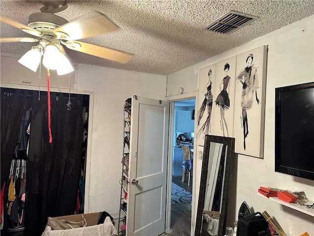 bedroom with a textured ceiling and ceiling fan