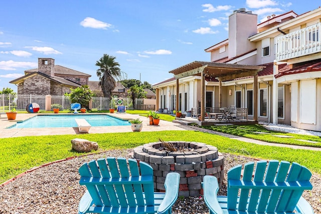 view of pool featuring a patio area, a yard, and a fire pit