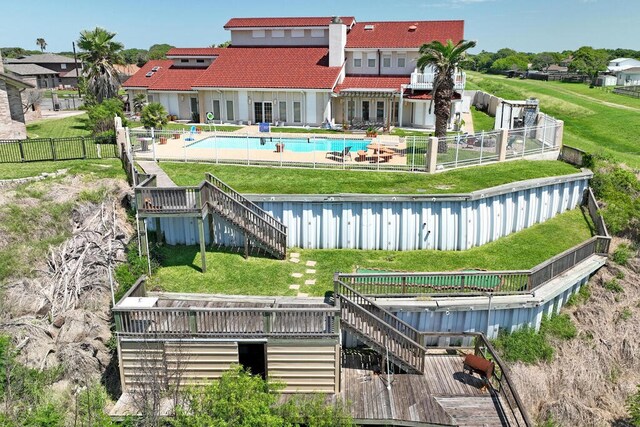 rear view of house with a patio area, a swimming pool side deck, and a yard