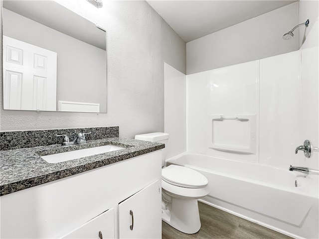 full bathroom with vanity, hardwood / wood-style floors, shower / washtub combination, and toilet