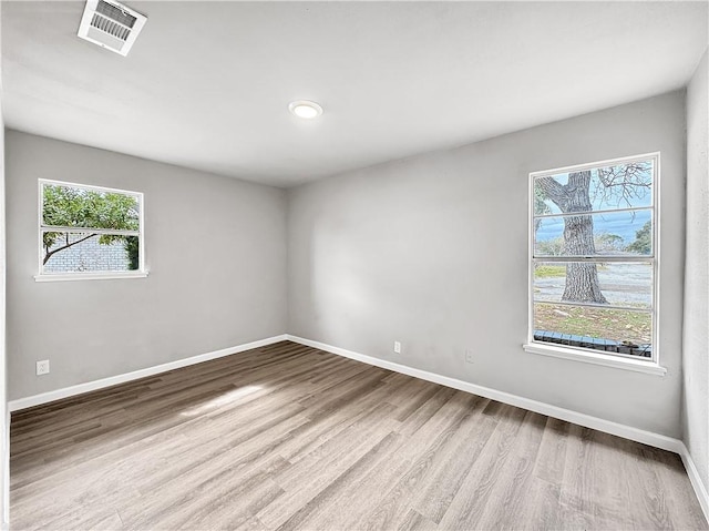 unfurnished room with wood-type flooring and a wealth of natural light