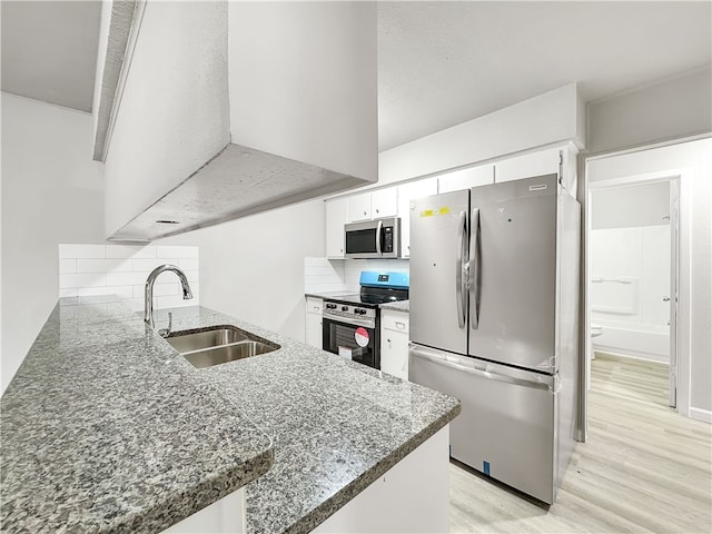 kitchen featuring white cabinetry, appliances with stainless steel finishes, sink, and kitchen peninsula