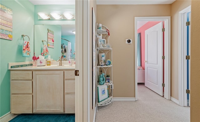 bathroom featuring carpet, baseboards, and vanity