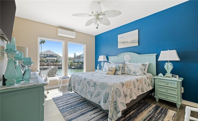 bedroom with a ceiling fan, an AC wall unit, baseboards, and wood finished floors