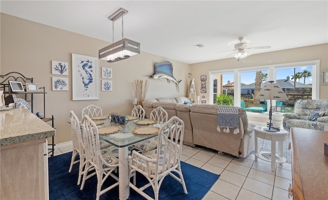 dining room with light tile patterned floors, visible vents, and a ceiling fan