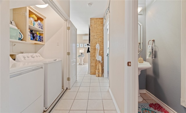 washroom with light tile patterned floors, baseboards, and washer and dryer