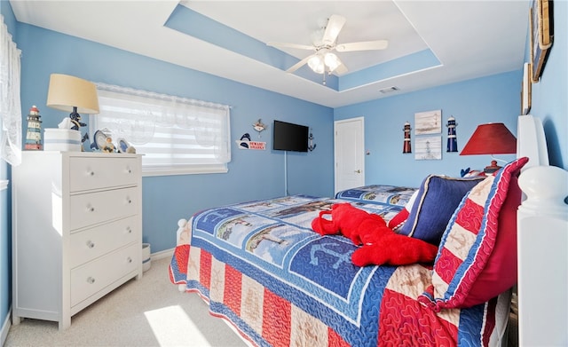 bedroom with baseboards, visible vents, a raised ceiling, ceiling fan, and carpet flooring