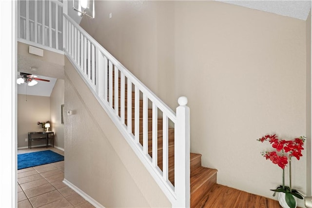 stairway featuring tile patterned flooring, vaulted ceiling, and ceiling fan