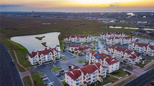 aerial view at dusk featuring a water view