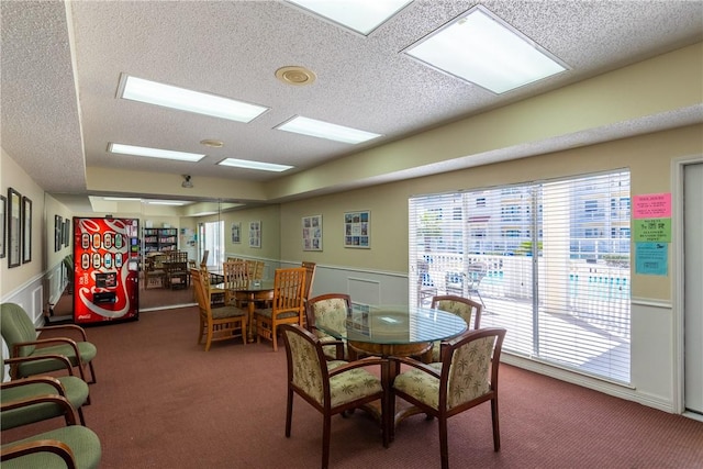 dining area featuring dark colored carpet and a wealth of natural light