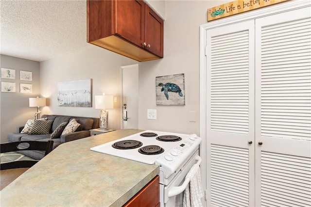 kitchen featuring a textured ceiling, open floor plan, brown cabinetry, and white electric range oven