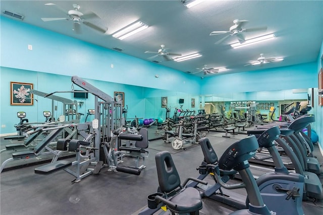 gym with ceiling fan and a textured ceiling