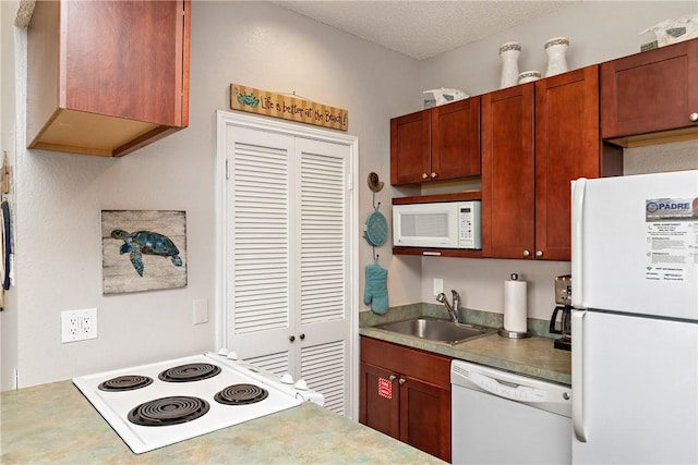 kitchen featuring white appliances, sink, and a textured ceiling