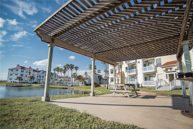 view of community featuring a yard, a pergola, and a water view