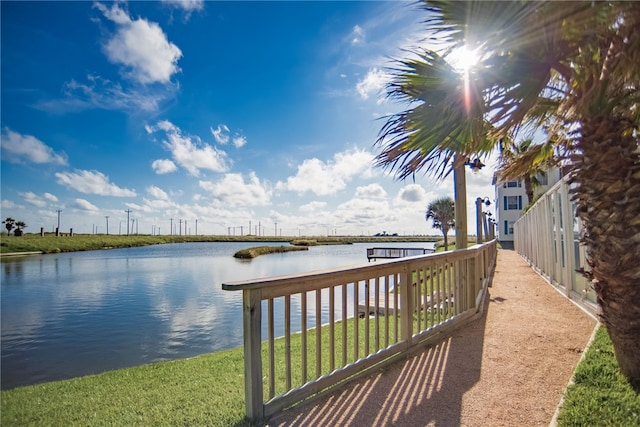 view of dock featuring a lawn and a water view