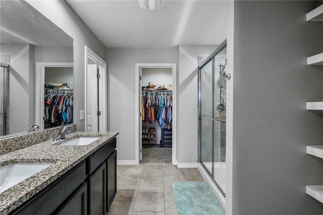 bathroom featuring tile patterned flooring, vanity, and a shower with door