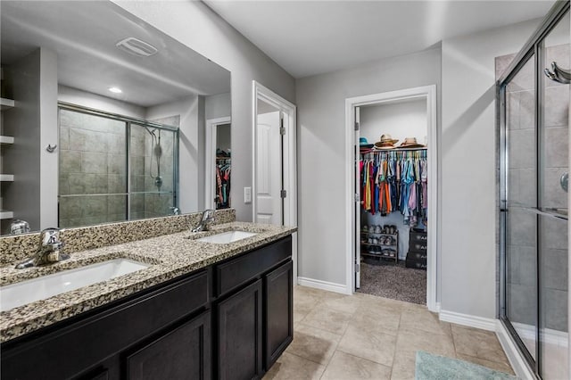 bathroom featuring tile patterned flooring, vanity, and walk in shower