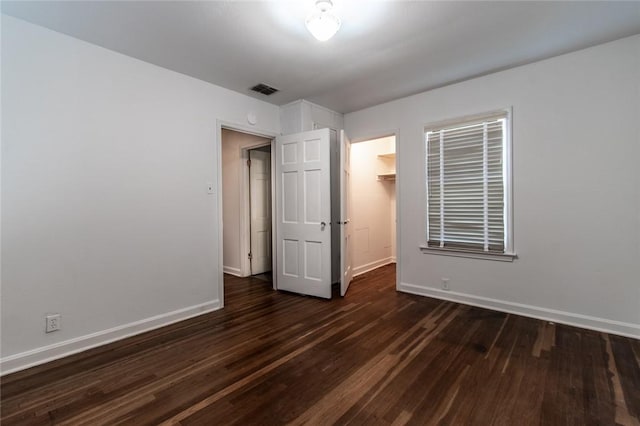 1522 Clodah Dr, Corpus Christi, TX 78404 - unfurnished bedroom with dark wood-style flooring, a closet, and a walk in closet